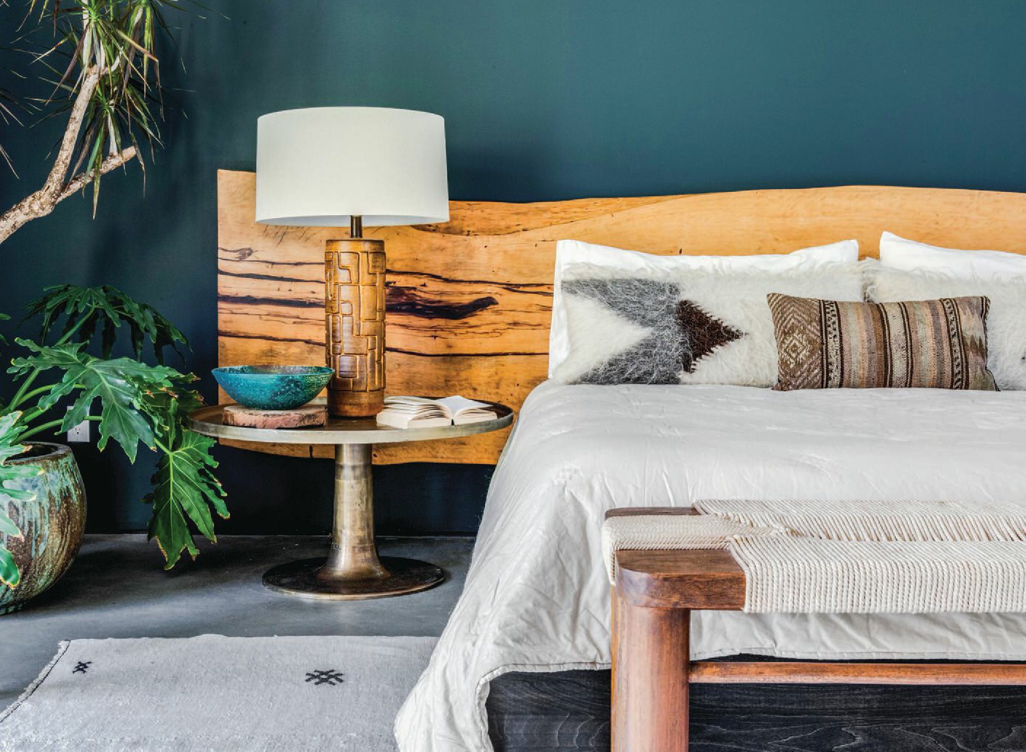 The master  bedroom’s headboard  was repurposed from a  live-edge dining room  tabletop divested of its  legs, discovered at HD  Buttercup. It’s hung on  a wall painted a custom  green blend by Benjamin  Moore. Th e bench is from  Four Hands PHOTOGRAPHED BY CHAD MELLON