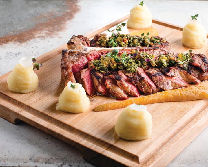 The shareable 32-ounce porterhouse includes sauteed zucchini, pomme puree, charred pickled pearl onions and salsa verde PHOTO COURTESY OF OUTSHINE PR