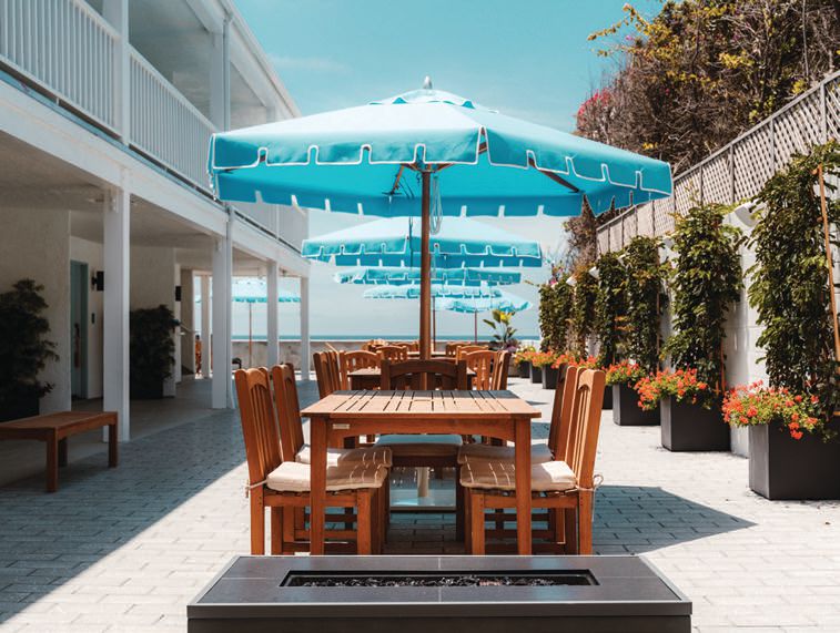 Shaded tables offer a place to gather on the hotel’s beachfront patio PHOTO BY NASH HAGEN