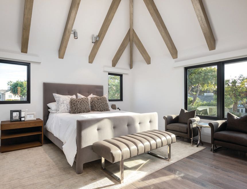 A guest bedroom includes soaring ceilings with wood accents PHOTO BY ADAM DUBICH