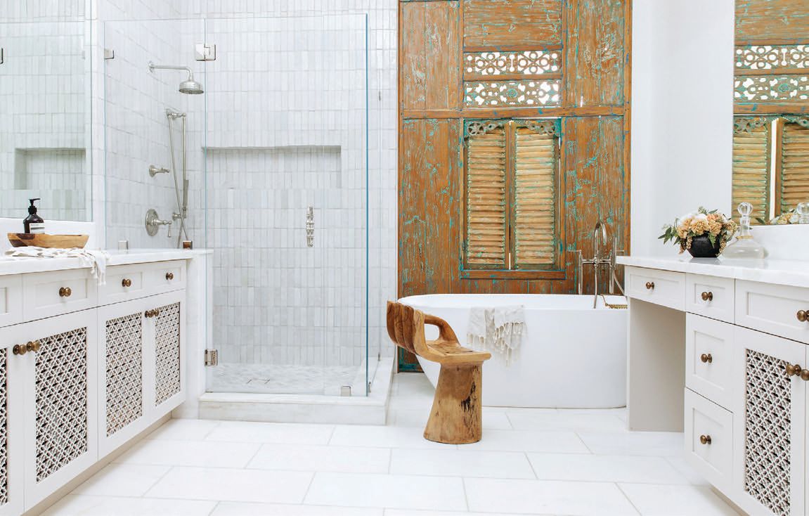 An antique wooden door from Bali is a backdrop for the primary bath. PHOTO COURTESY OF ANGELA O’BRIEN